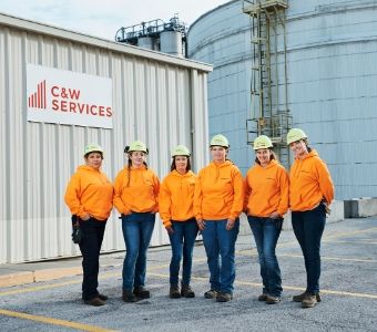 A team of female maintenance workers pose for a photo outside of a site in Nebraska
