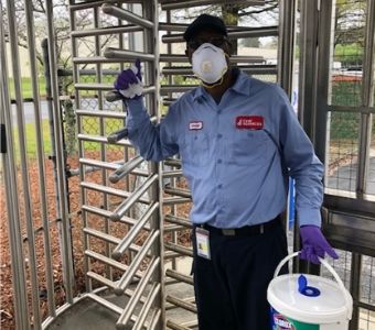 A C&W Services employee disinfects gate entry
