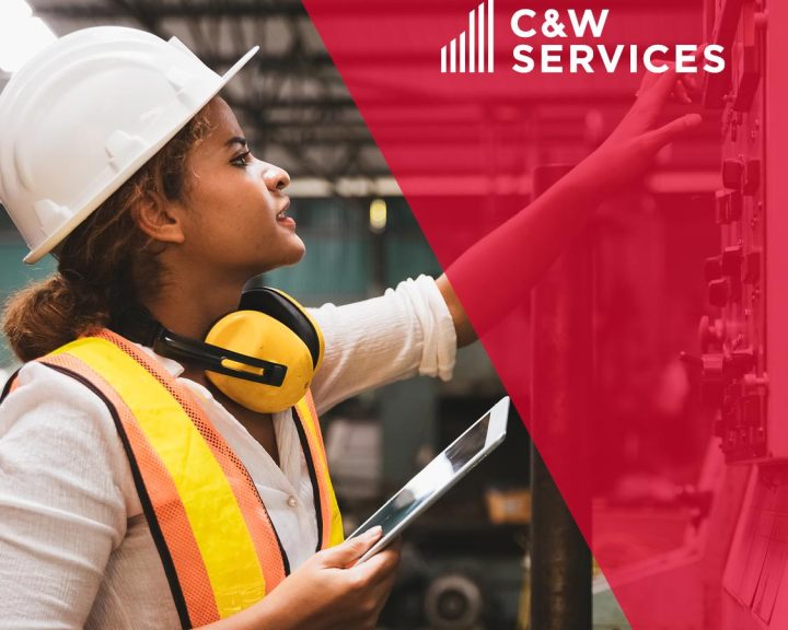 A woman wearing a hard hat and hard hat with the words caw services.