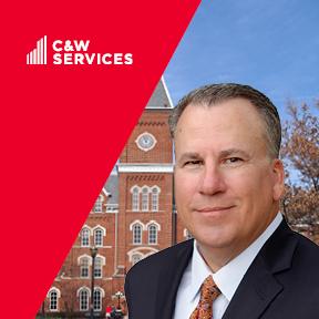 A man in a suit standing in front of a building.