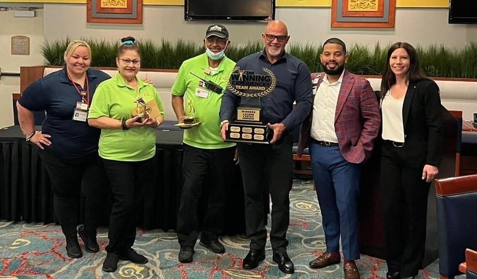 A group of people posing for a picture with a trophy.