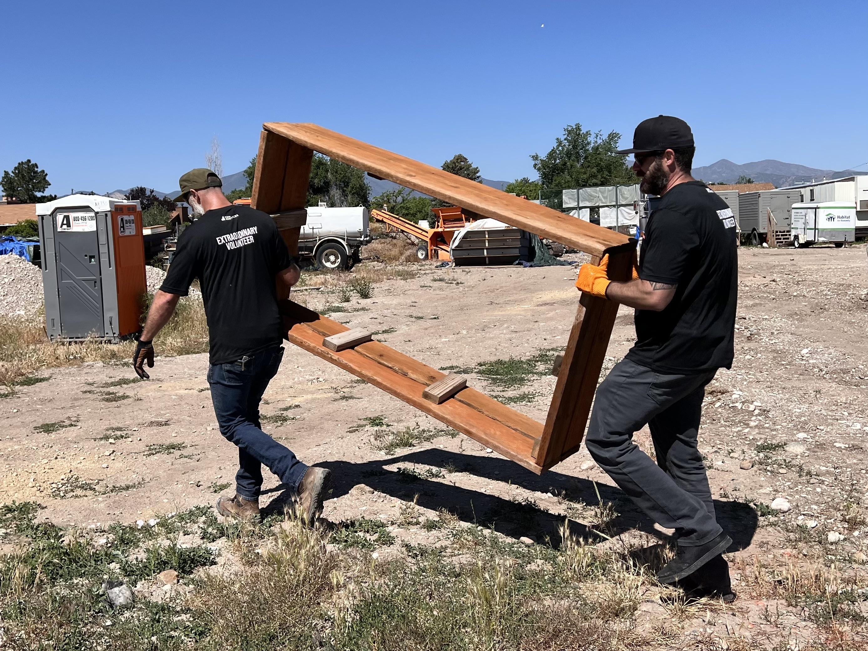 C&W Services volunteers carrying shelving from Habitat for Humanity site
