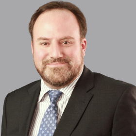 A bearded man in a suit and tie.