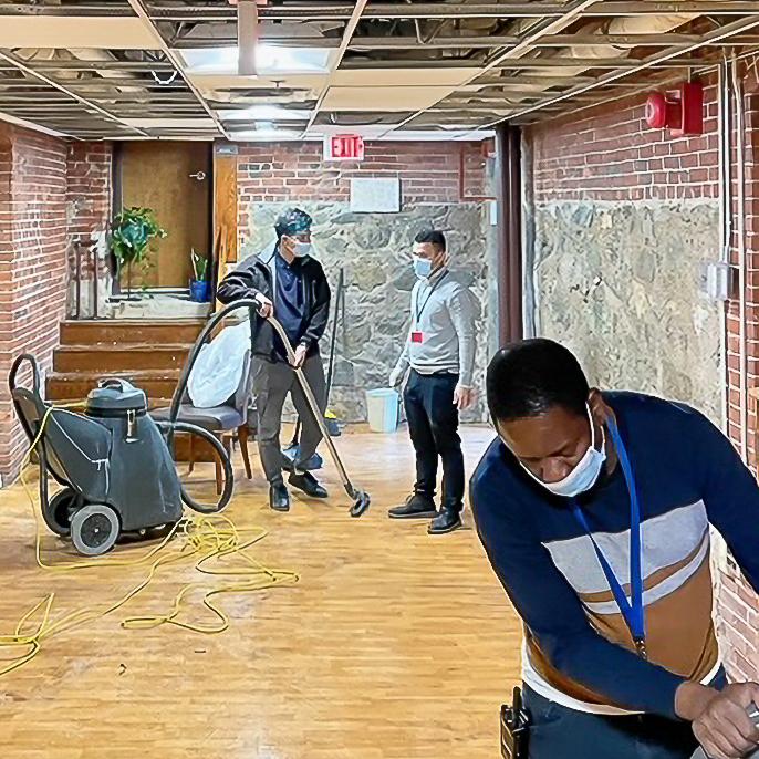 A group of people working on a floor in a building.