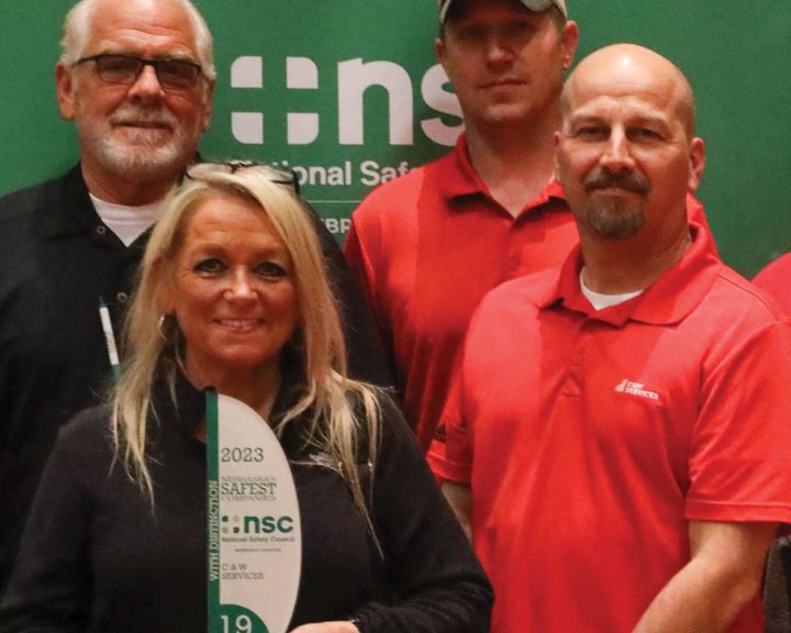 A group of people posing for a picture with an award.