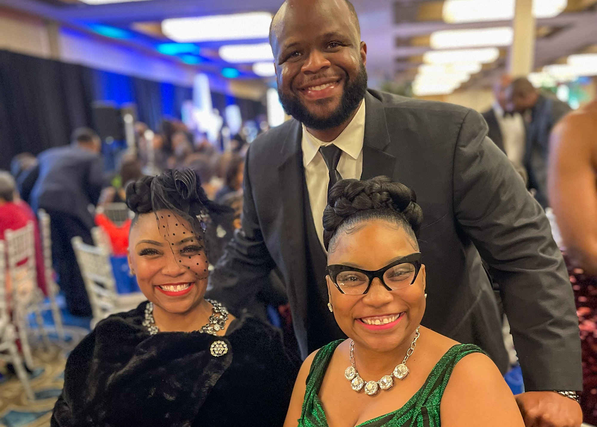 Three people posing for a photo at an event.