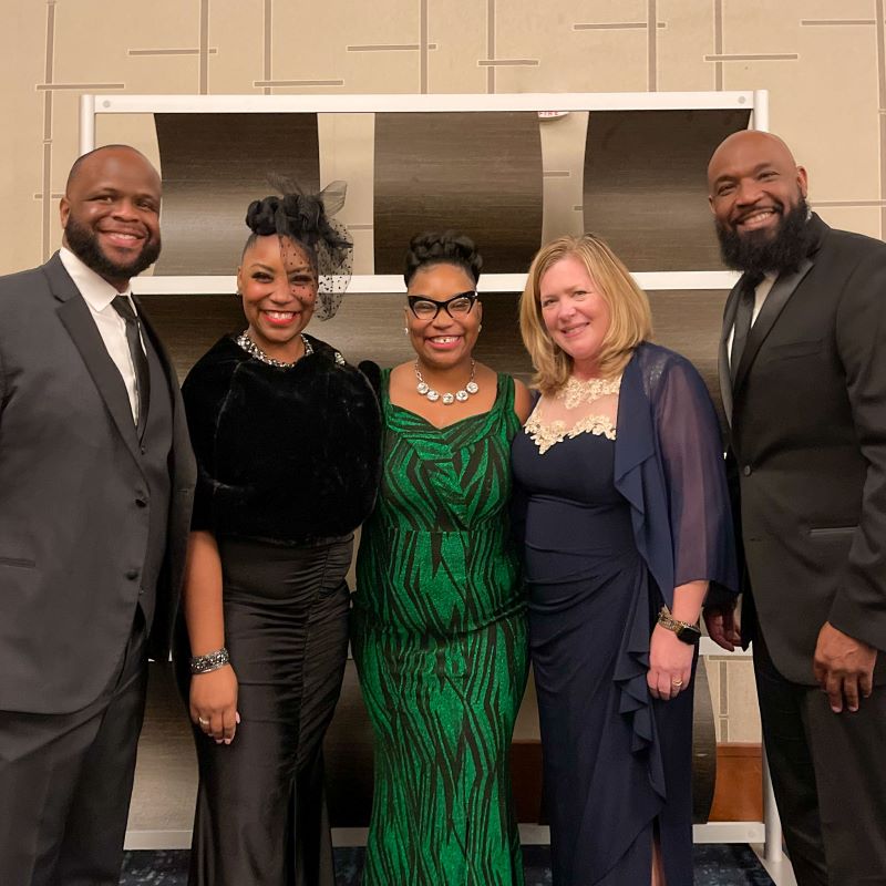 Four people in formal attire posing for a photo.