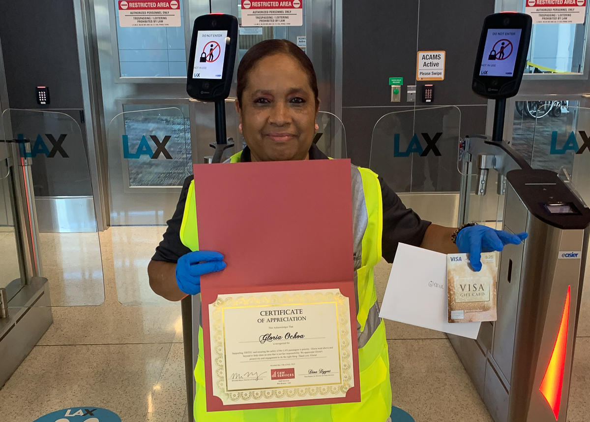 A woman in a safety vest holding a certificate and gift card
