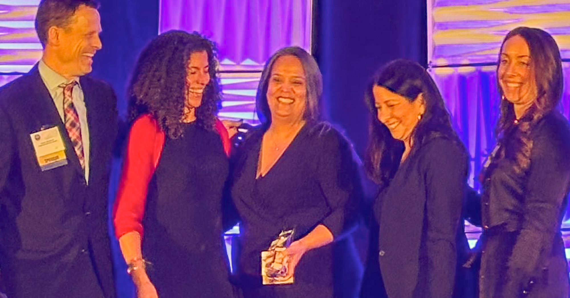 A group of people posing for a photo with an award.