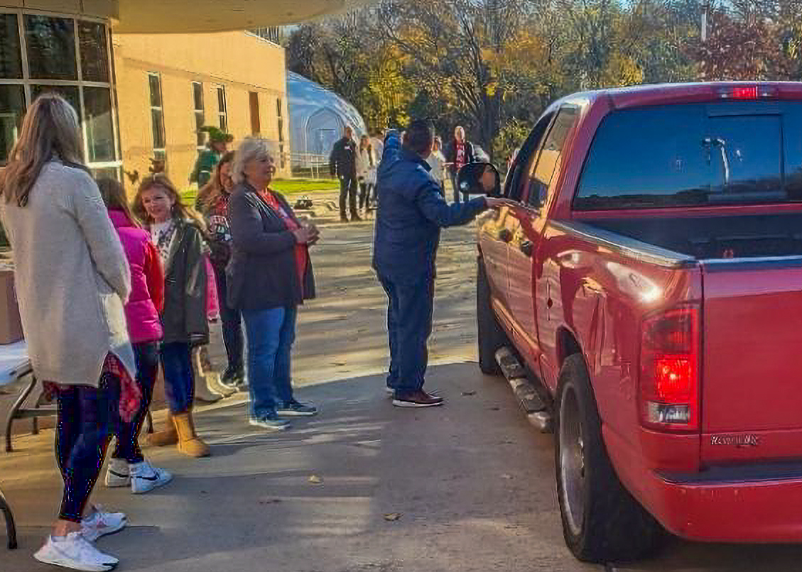 A group of people standing in front of a red truck.