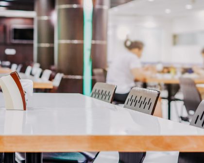 A college cafeteria with empty tables and chairs.